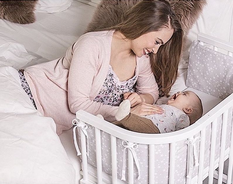 Белая приставная кроватка с младенцем